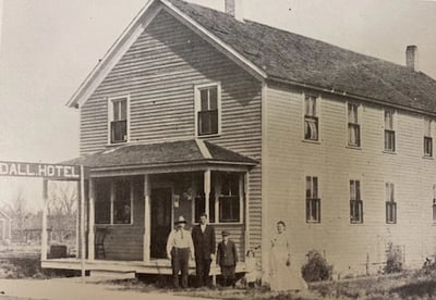 Black and white photo of a family standing outside in front of the Schwanke Hotel