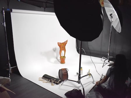 A wooden bowl with handles in photostudio being photographed