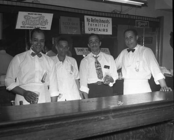 African American Bartenders standing behind bar. ca 1940s