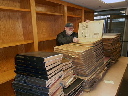 Volunteer, Rich Glennie, examining one of the Chronicle compillation books at Chroncicle offices