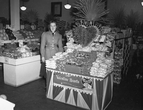 1951 photo of a woman standing next to a Valentine candy display in grocery store