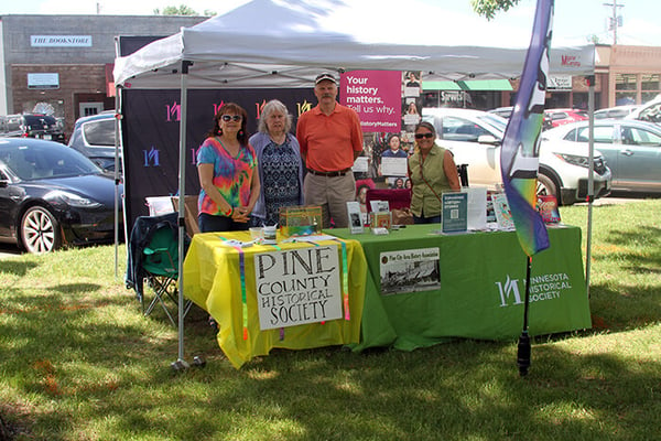 Booth at East Central Minnesota Pride with four people staffing the table