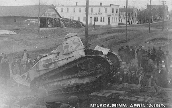 Tank being unloaded off platform photo labeled-MILACA, MINN, APRIL 12, 1919