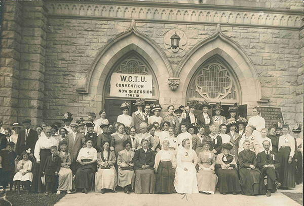 Womans Christian Temperance Union in front of church entrance. Banner above door says Convention now in session