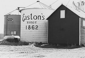 Two silos next to farm out building. One silo says Eastons since 1862