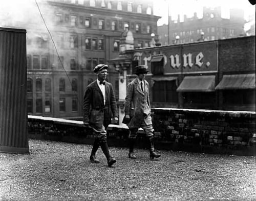 A man and woman hiking on Minneapolis building rooftops in the vicinity of the Journal and Tribune buildings on Fourth Street, ca. 1925