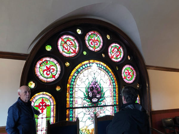 Two people in front of a stained glass window at the Scottish Rite Temple in Minneapolis