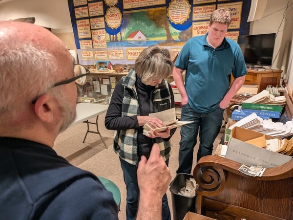 Three people looking through boxes of photographs