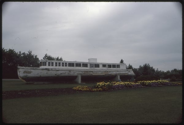 Side image of the boat Golden Bantum on land held aloft by concrete  supports, Ortonville, MN-Sept. 1985