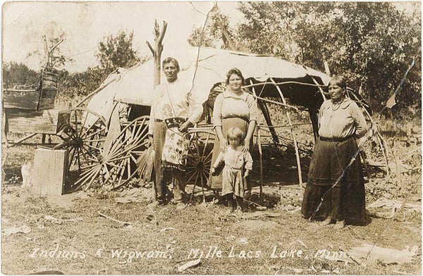 Postcard showing Ojibwe family and wigwam, one man, two women and a small child