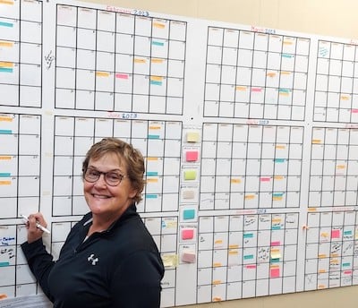 Deb working on the Runestone Museum calendar which takes up it own wall.