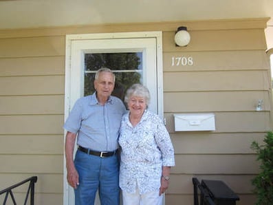 Photo of Mel and Lucy Johnson in front of door to home