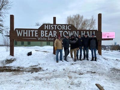 Volunteers standing in front of the sign