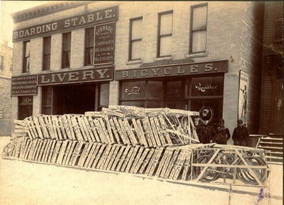 Stacks of bicycles in crates in front of the Frederick Roach bike shop at 519 Hennepin Avenue, ca.1902