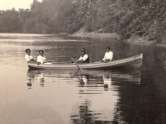 African-American family of four in row boat  on the St. Croix ca. 1905