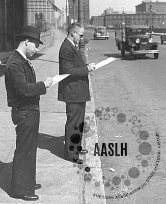 Two men taking survey standing on sidewalk near street, ca1930s -AASLH logo is superimposed over image