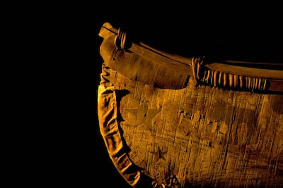 Image of the bow of a birch bark canoe. Barely seen in bark are designs of stars and a moose