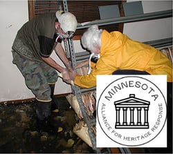 Flood room with two people in protective gear bagging records