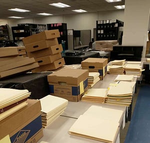 Boxes, folders and papers waiting to be archived