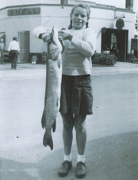 Girl holding very large fish almost as big as her