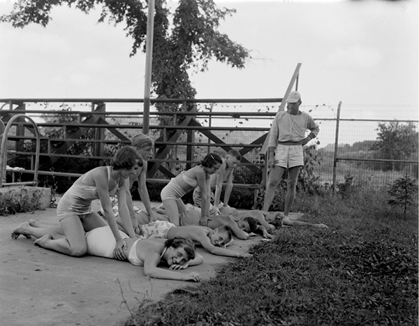 A Group of lifeguards training in 1947 with trainer looking on