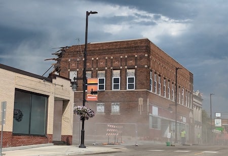 A two-story brick building on commerical main street with its back half demolished