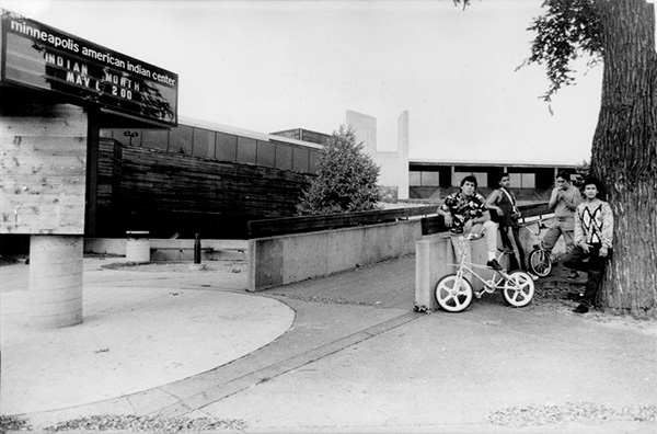 Four male Native American youths standing and chillin outside of the Minneapolis American Indian Center