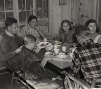 Black and white photograph of Governor Elmer Benson eating breakfast with his family at their cabin on the North shore of Lake Superior, 1937.