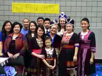 Color image of participants in the Operation Free Flu Shot program gather for a group photograph at Hmong Village in St. Paul on October 27, 2013.