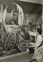 Black and white photograph of artist John Socha at work on a Works Progress Administration mural at the New Ulm High School, 1941.