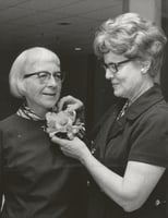 Black and white photograph of St. Catherine’s alumna Betty Hubbard (right) pinning a corsage on Alice Gustava Smith (Sister Maris Stella, left) at the College of St. Catherine in 1971. Photographed by P.J. Strasser.
