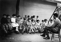 Black and white photograph of a man telling a story to residents of the Jewish Sheltering Home for Children in Minneapolis, c.1925.