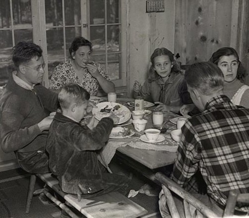 Black and white photograph of Governor Elmer Benson eating breakfast with his family at their cabin on the North shore of Lake Superior, 1937.