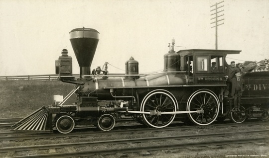 Black and white photograph of James J. Hill with two engineers on the William Crooks train engine, 1908. Photograph by T.W. Ingersoll.