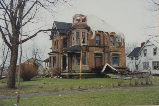 Photograph of badly damaged house.